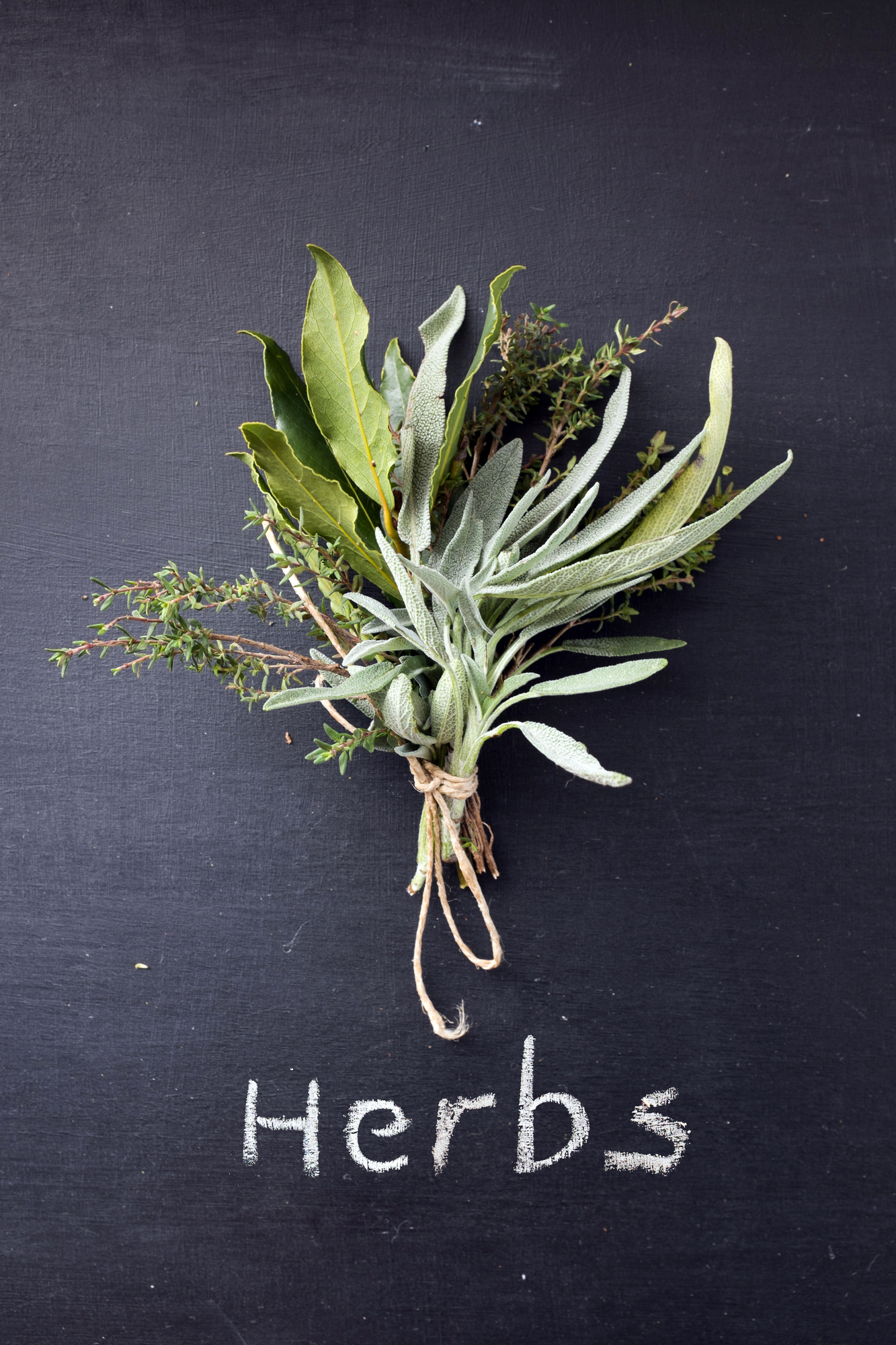 Tied fresh herbs on blackboard