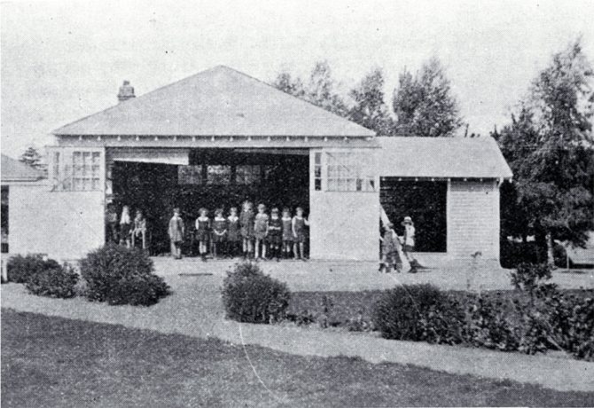 By the 1920s most parents were being guided by the Plunket Society to realise the benefits of fresh-air and sunlight for their children and the Christchurch Open-Air League had been able to persuade the Canterbury Education Board to build some open-air classrooms. The most common type was like this one at Fendalton School, Christchurch, where on sunny days, sliding doors allowed one whole wall to be opened to allow in fresh air and sunshine. Each pupil had a desk and chair which could be carried outside in fine weather. The porch on the right-hand side of the photograph served as a cloakroom and shelter-shed
