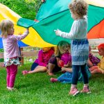Kids play outside with a parachute