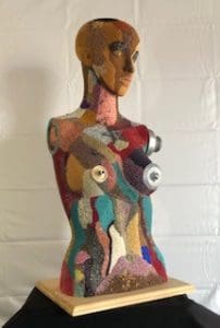 Image is of a colorful bead covered woman's head and torso