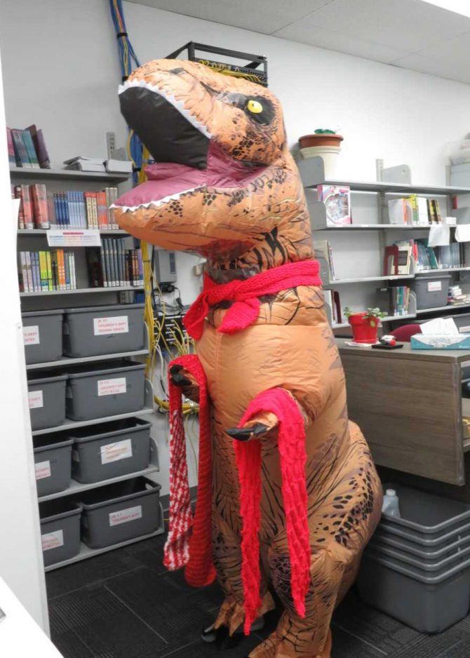 An inflatable Tyrannosaurus rex collects red scarves
