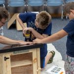 Library staff helping teens construct a Little Free Library to place out in the Xenia community.
