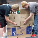 Teens building a cardboard structure