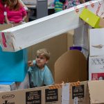 A child builds with cardboard boxes