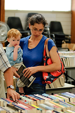 Woman with baby looking at donated books.