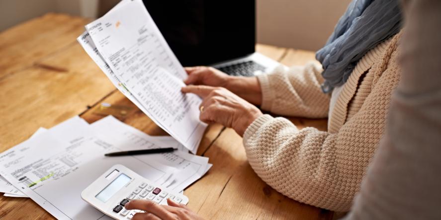 Cropped view of a senior woman receiving help with her finances from her