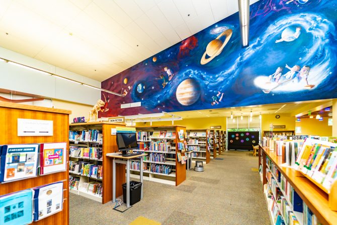 <p>Morgan Hill Library Children's books, shelves, mural</p>