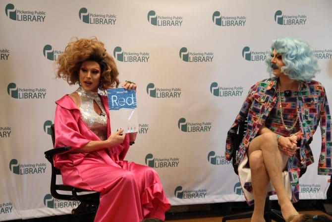 Image of two drag queens reading a children's story.