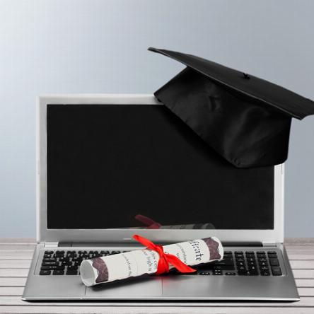 Graduation cap and diploma sitting on a laptop computer, Brainfuse