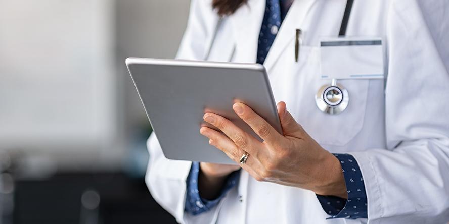Doctor looking at a tablet, Consumer Health Complete