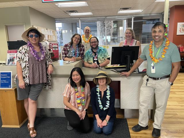Library staff dressed in beachwear at the main desk at the Downtown Branch